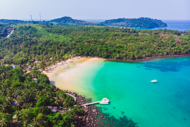 Aerial view of beautiful beach and sea with coconut palm tree on blue sky in the paradise island